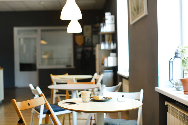 Leeres Café mit Kaffee, Smartphones und Kuchen auf dem Tisch. - Foto, Bild