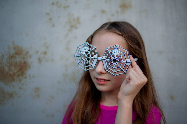 Dziewczyny w okularach. Halloween koncept.Dziewczyna w wieku 9-10 lat nosiła okulary z projektu pająka na Halloween - Zdjęcie, obraz
