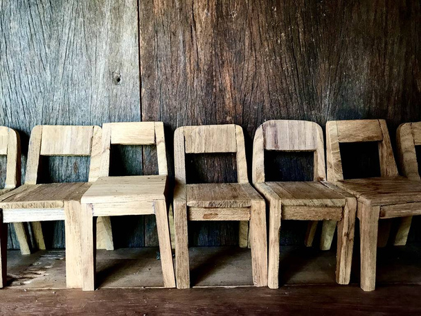Sok mini fa székek kerültek sorba a fa padló, háttér fából készült fal. Díszterem. - Fotó, kép