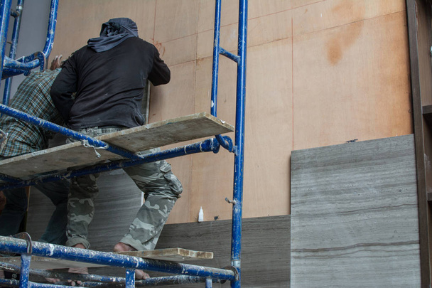márvány elhelyezése a falon, márvány beszerelése az építkezésen. - Fotó, kép
