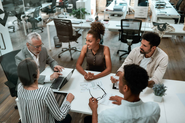 Вид зверху бізнесменів обговорює щось під час спільної роботи в сучасному офісі
 - Фото, зображення