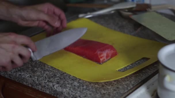 Cook cuts fish meat by knife in the kitchen, chef prepares for cooking, dishes with fish, diet food - Felvétel, videó