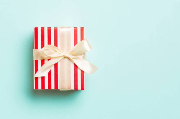 Κουτί δώρου με κίτρινο φιόγκο για την ημέρα των Χριστουγέννων ή της Πρωτοχρονιάς σε μπλε φόντο, κορυφαία προβολή με αντίγραφο χώρου - Φωτογραφία, εικόνα