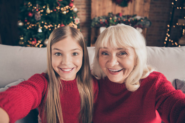 Self-portrait of nice attractive lovely charming glad cheerful cheery granny pre-teen grandchild spending wintertime vacation day at decorated industrial loft style interior house - Foto, immagini