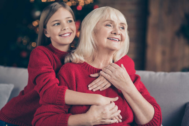 Close-up portrait of nice attractive lovely sweet careful affectionate cheerful cheery granny grandchild sitting on cosy divan holding hands cuddling at decorated industrial loft style interior house - Foto, afbeelding