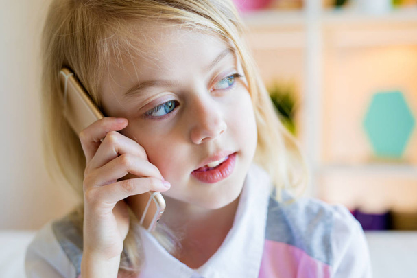 Portrait de mignonne fille heureuse en utilisant le téléphone cellulaire parler
 - Photo, image