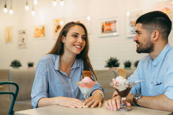 Woman and man eating ice cream in favorite cafeteria - Foto, imagen