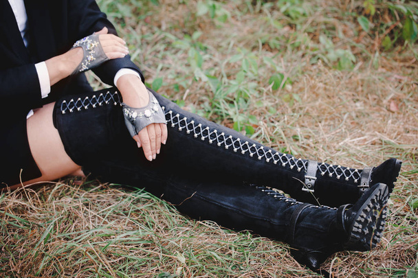 Woman in boots lace-up sitting on the grass - Φωτογραφία, εικόνα