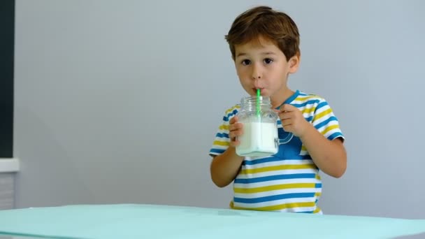 slow motion asiático bonito menino bebendo leite na cozinha. menino alegre gosta de beber milkshake
 - Filmagem, Vídeo