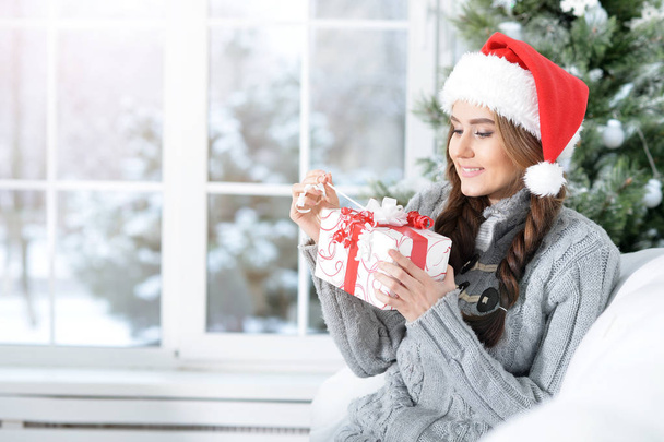 Portrait of smiling woman with Christmas gift  - Фото, изображение