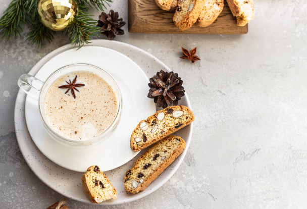 Eggnog. Christmas milk cocktail with cinnamon and anise, served in glass mug with biscotti, winter spices, fir branches and cones. - Фото, зображення