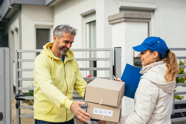 senior man receiving packages from courier - Foto, Imagem