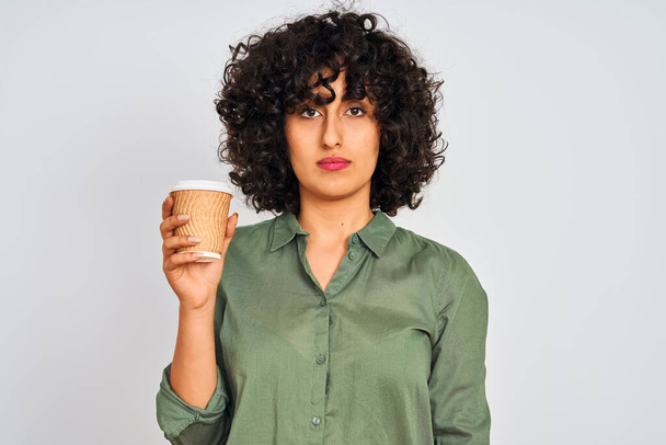 Молода арабська жінка з кучерявим волоссям п'є чашку кави над ізольованим білим тлом з впевненим виразом на розумному обличчі, думаючи серйозно
 - Фото, зображення