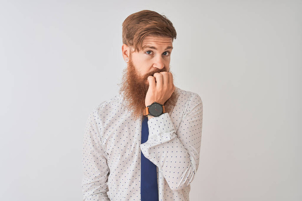Young redhead irish businessman standing over isolated white background looking stressed and nervous with hands on mouth biting nails. Anxiety problem. - Photo, Image