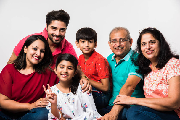Indian Kids with parents / grandparents, sitting isolated over white background, studio shot - Photo, Image