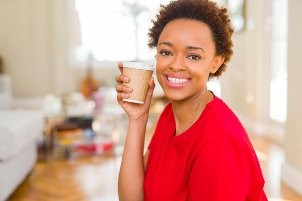 美しい若いアフリカ系アメリカ人女性を離れて紙コップでコーヒーを飲んで - 写真・画像
