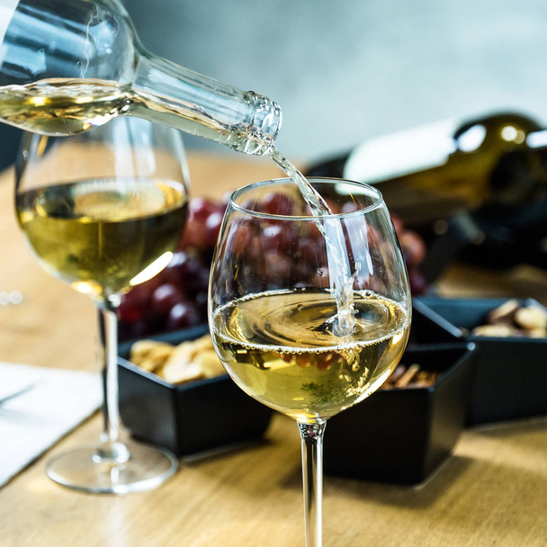 Крупный план разлива белого вина в ресторане
 - Фото, изображение
