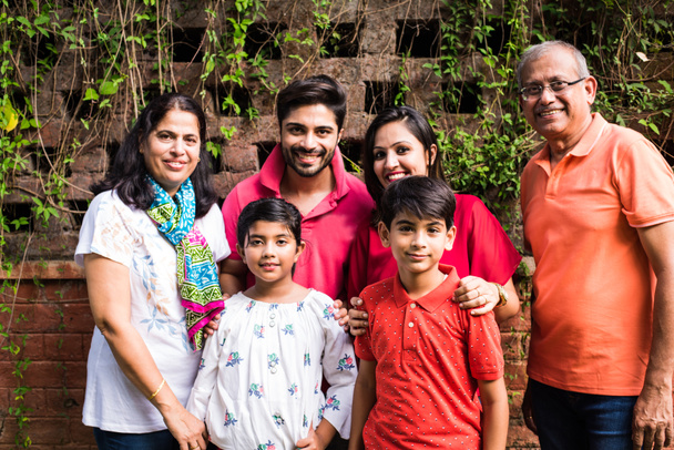 Indiánská rodina stojí v řadě u zdi pokryté šlahouny. Multi generace asijské rodiny v parku nebo zahradě baví, zdravý rodinný život koncept - Fotografie, Obrázek