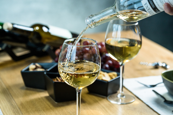 Großaufnahme von einschenkendem Weißwein im Restaurant - Foto, Bild