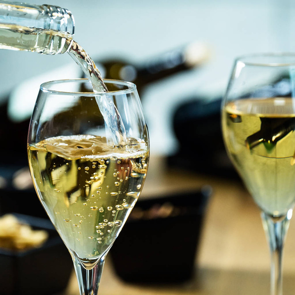 Closeup of pouring white wine in restaurant - Photo, Image