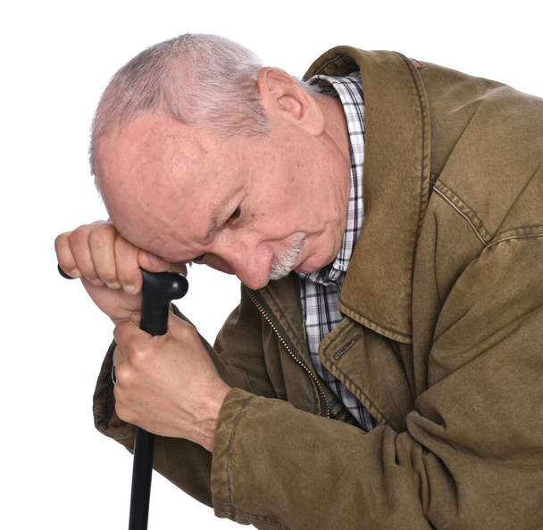 Λυπημένος μοναχικός ηλικιωμένος με μπαστούνι που ποζάρει στο στούντιο  - Φωτογραφία, εικόνα