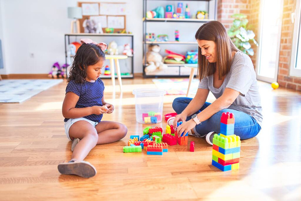 美しい先生と幼児の女の子遊びます建設ブロックbulding塔とともに幼稚園 - 写真・画像