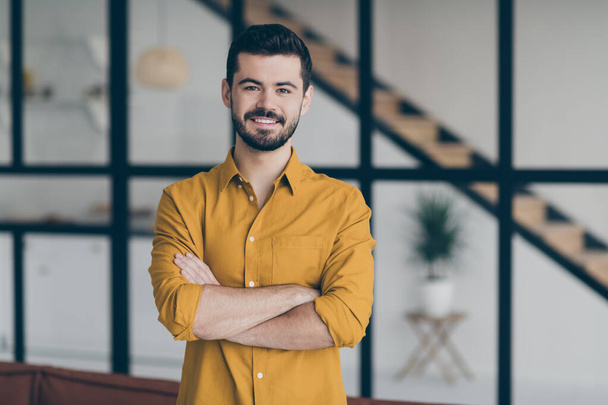 Photo of handsome guy with crossed hands standing in modern interior apartments indoors going to make rebuild office room for company members - Zdjęcie, obraz