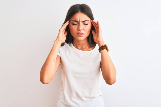 Mladá krásná žena na sobě ležérní tričko stojí nad izolovaným bílým pozadím s rukou na bolesti hlavy, protože stres. Trpící migréna. - Fotografie, Obrázek