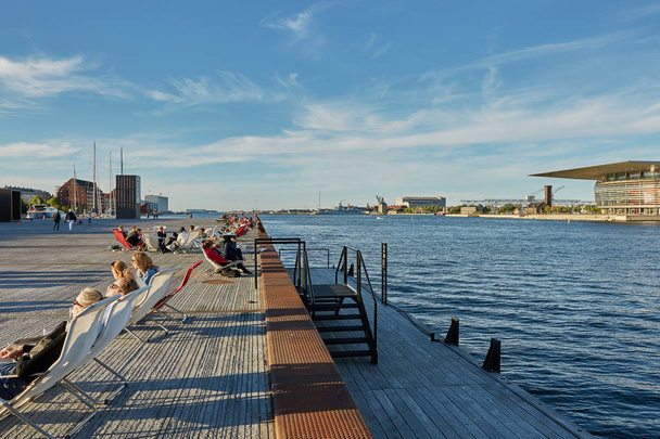 People relaxing and enjoying afternoon's sun with The National Opera House "Operaen"  in the background. - Photo, Image
