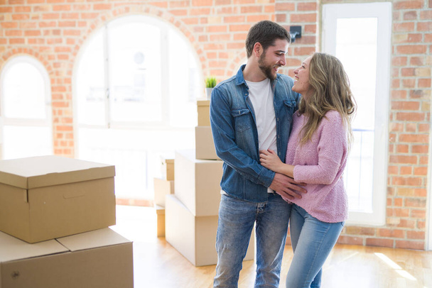 Jeune beau couple regardant heureux ensemble déménageant dans une nouvelle maison
 - Photo, image
