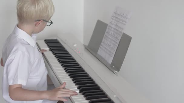 O menino toca piano eletrônico em partituras
 - Filmagem, Vídeo