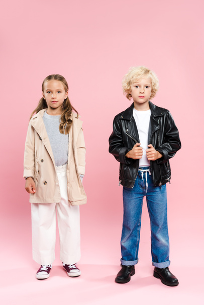 kids in coat and leather jacket looking at camera on pink background  - Valokuva, kuva