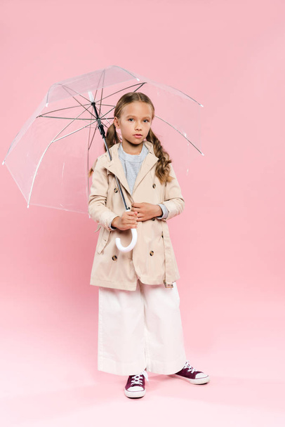 kid in autumn outfit holding umbrella on pink background  - Photo, Image