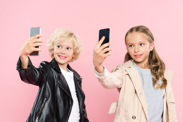 smiling and cute kids taking selfie on pink background  - Foto, Imagem