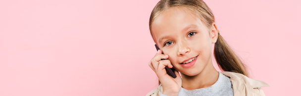 panoraama laukaus hymyilevä lapsi puhuu älypuhelimella eristetty vaaleanpunainen
 - Valokuva, kuva