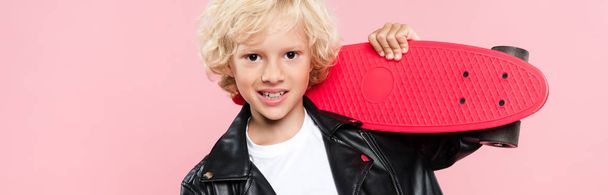 ピンクで隔絶されたペニーボードを持っている笑顔とかわいい子供のパノラマショット - 写真・画像