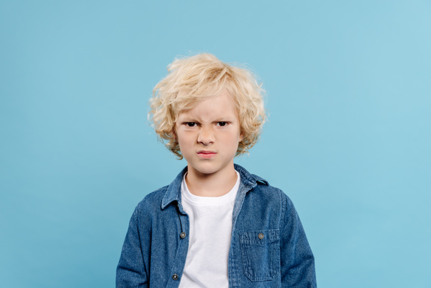 irritated and cute kid looking at camera isolated on blue  - Zdjęcie, obraz