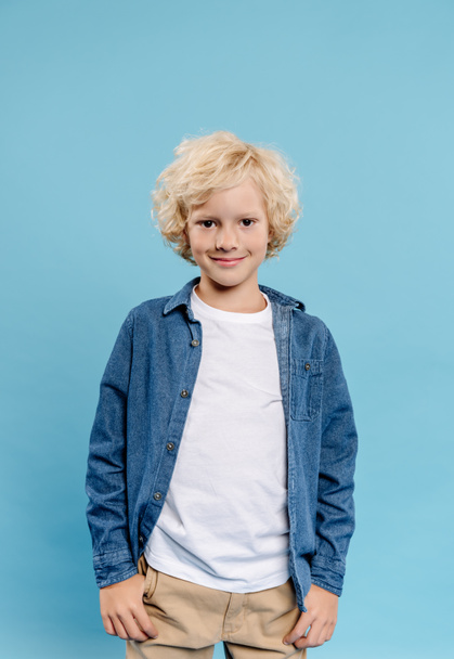 smiling and cute kid looking at camera isolated on blue  - Foto, Imagem