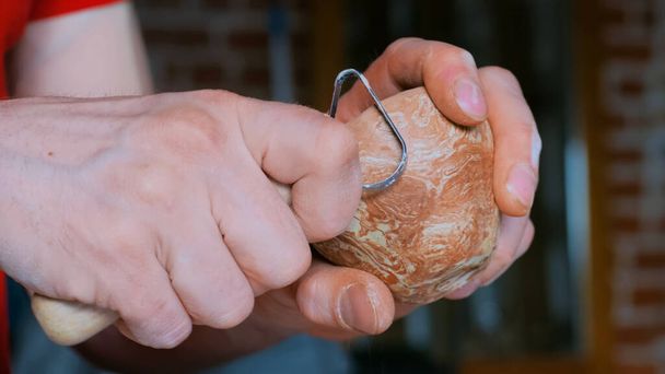 Professional potter shaping dry clay cup with special tool in pottery workshop - Photo, Image