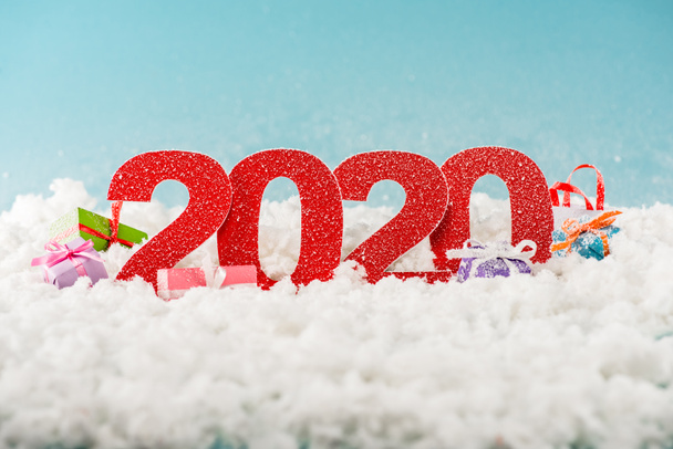 números 2020 y cajas de regalo de Navidad en nieve blanca
  - Foto, imagen