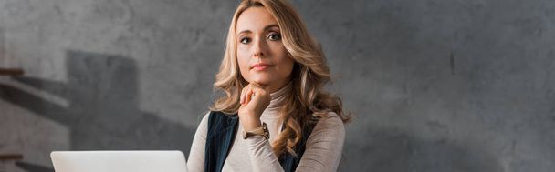 panoramic shot of attractive and dreamy businesswoman looking at camera  - Фото, зображення