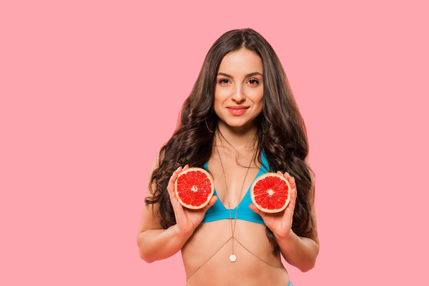 mujer feliz y sexy sosteniendo pomelos aislados en rosa
 - Foto, Imagen