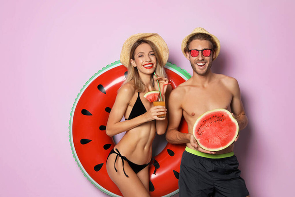 Happy young couple in beachwear on pink background. Fruit sunglasses as summer trend - Foto, Imagem
