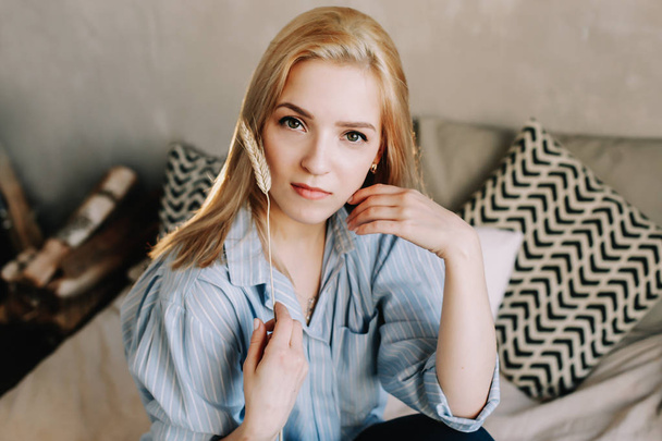 Portrait of a young beautiful woman in bed in the morning at home. Blonde girl in scandinavian interior. Good morning. Lifestyle. - Photo, Image