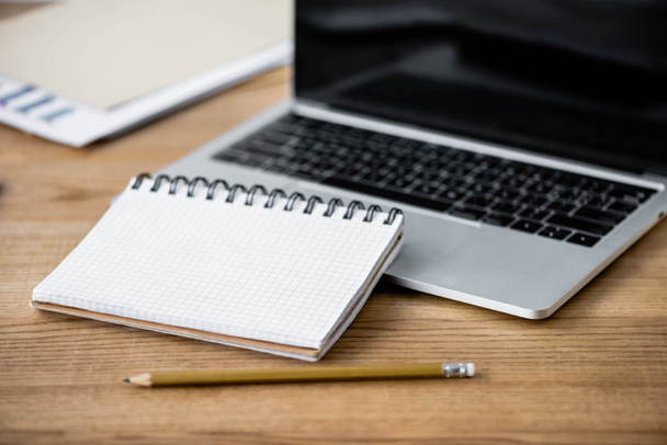 szelektív fókusz notebook, toll és laptop fa asztalon  - Fotó, kép