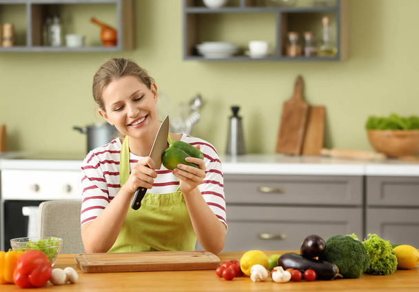 Beautiful young woman cooking in kitchen - Foto, Bild