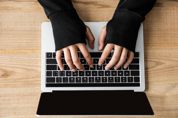 обрезанный вид хакера, сидящего за столом и использующего ноутбук
  - Фото, изображение