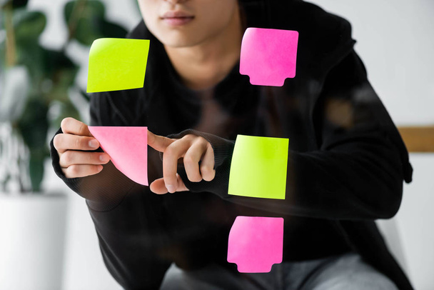 cropped view of seo manager putting on glass colorful sticky note  - Photo, Image