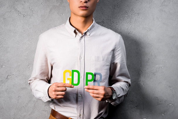 vista cortada de empresário segurando coloridas letras gdpr
  - Foto, Imagem
