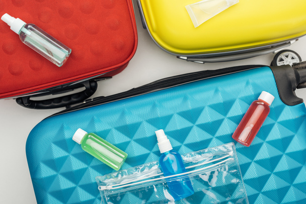top view of bright bottles with liquids on travel bag  - Fotografie, Obrázek